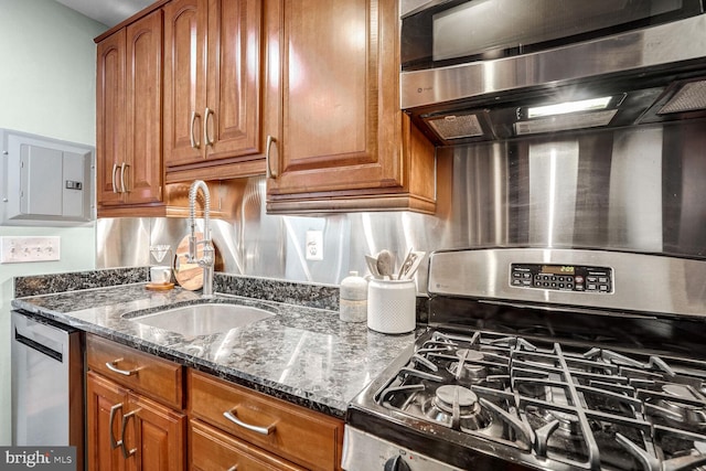 kitchen featuring sink, stainless steel appliances, dark stone countertops, and electric panel