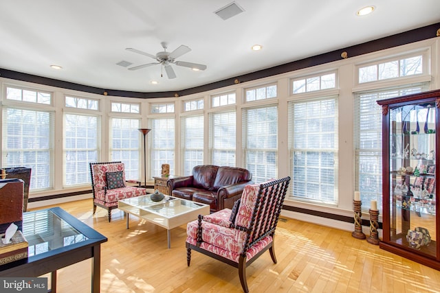 living room featuring visible vents, light wood-style floors, and a healthy amount of sunlight