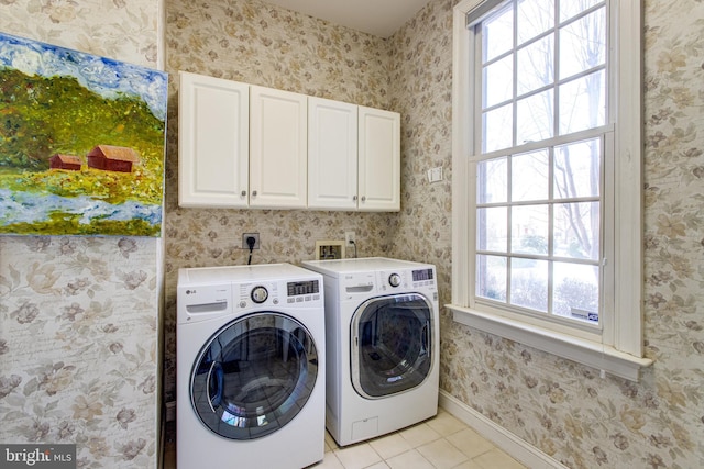 clothes washing area featuring cabinet space, light tile patterned flooring, wallpapered walls, baseboards, and washing machine and clothes dryer