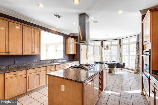 kitchen with visible vents, island exhaust hood, a kitchen island, appliances with stainless steel finishes, and crown molding