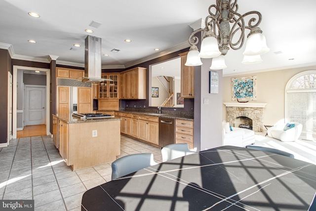 kitchen with gas cooktop, a kitchen island, light tile patterned flooring, a fireplace, and island range hood