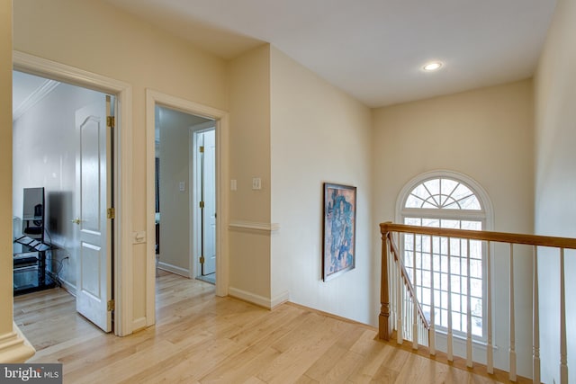 hallway with wood finished floors, recessed lighting, and an upstairs landing