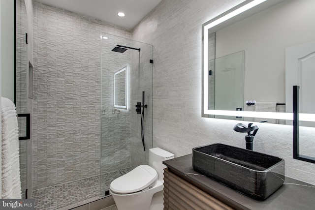 bathroom featuring vanity, tile walls, toilet, and walk in shower