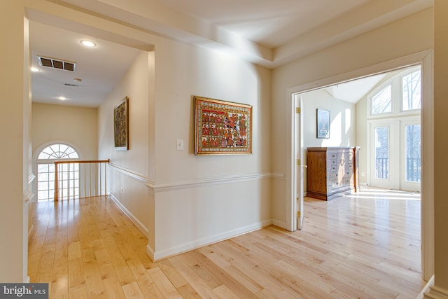 hall featuring visible vents, baseboards, light wood-type flooring, vaulted ceiling, and recessed lighting