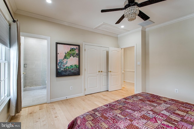 bedroom featuring baseboards, visible vents, light wood finished floors, attic access, and ornamental molding