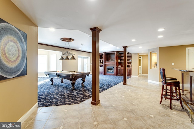 playroom featuring crown molding, baseboards, decorative columns, recessed lighting, and a fireplace