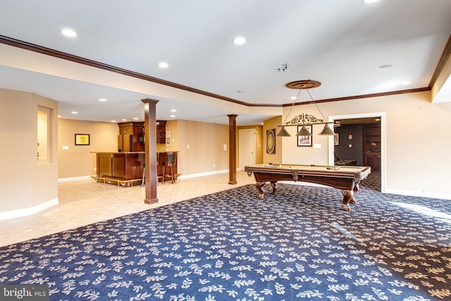 game room featuring tile patterned flooring, a bar, baseboards, and decorative columns