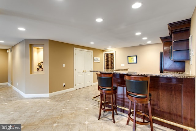 bar featuring indoor wet bar, light tile patterned floors, recessed lighting, and baseboards