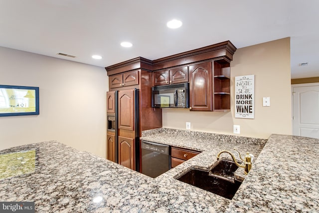 kitchen featuring light stone counters, visible vents, recessed lighting, a sink, and black appliances