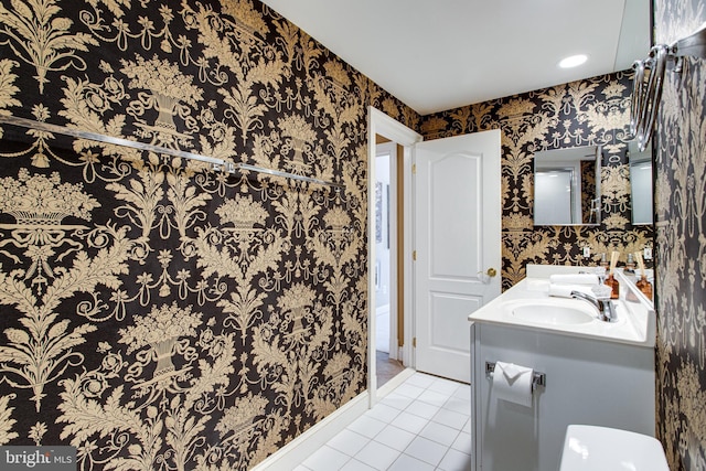 full bath with a sink, baseboards, tile patterned floors, and wallpapered walls