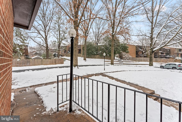 snowy yard featuring fence