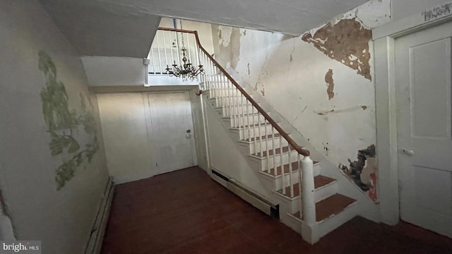 stairway featuring a baseboard heating unit