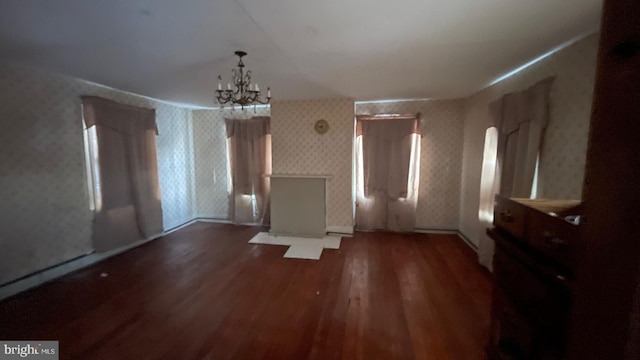 unfurnished dining area with dark hardwood / wood-style flooring and an inviting chandelier