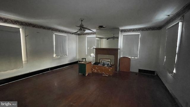 unfurnished living room featuring ceiling fan and hardwood / wood-style floors