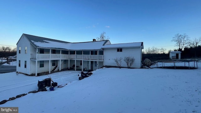 snow covered back of property featuring a trampoline