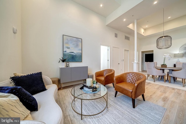 living room featuring a high ceiling and light wood-type flooring