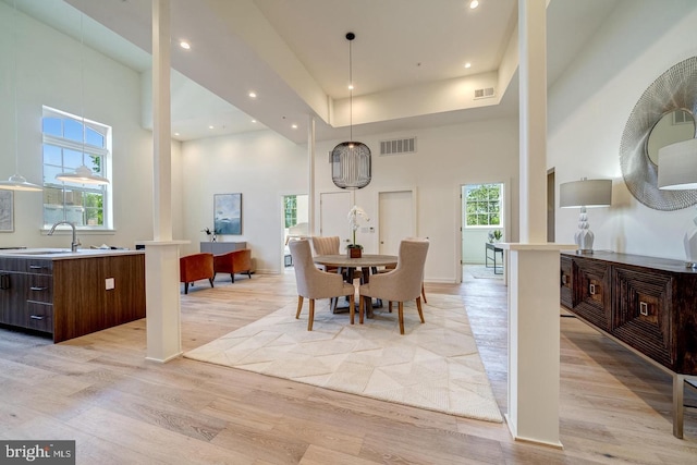 dining room featuring a high ceiling, sink, and plenty of natural light