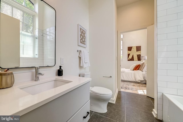 bathroom with toilet, vanity, and tile patterned floors