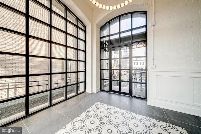 interior space with a high ceiling, tile patterned floors, and floor to ceiling windows