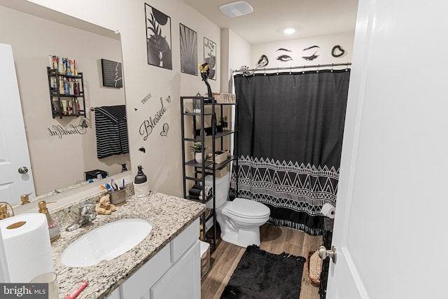 bathroom with toilet, hardwood / wood-style flooring, a shower with curtain, and vanity