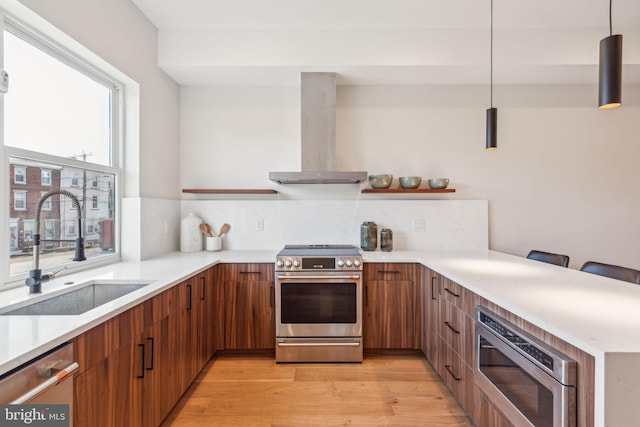 kitchen featuring stainless steel appliances, pendant lighting, sink, extractor fan, and tasteful backsplash