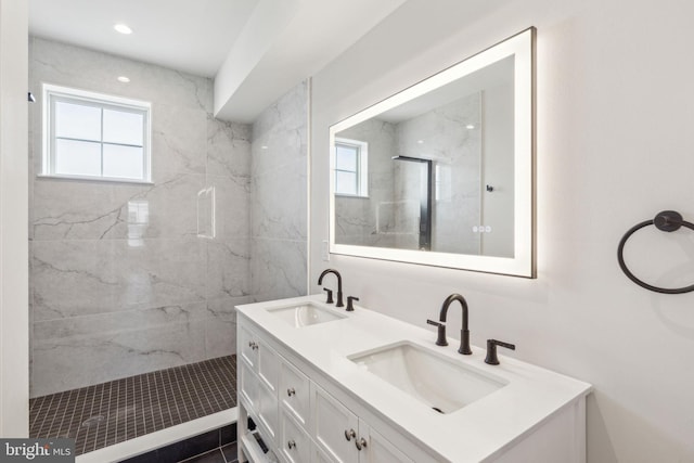 bathroom with tiled shower and vanity