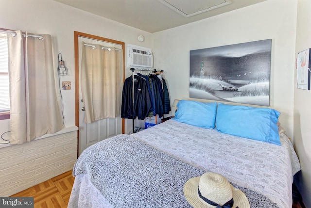 bedroom with a wall mounted air conditioner and parquet floors