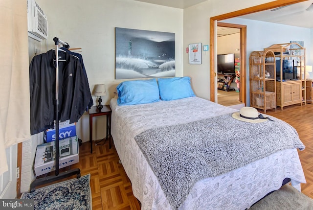 bedroom with a wall mounted AC and light parquet floors