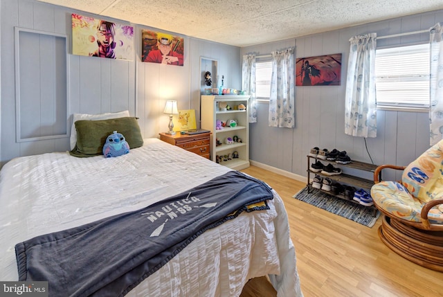 bedroom with wood walls and hardwood / wood-style floors