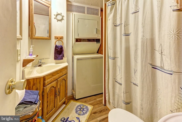 bathroom featuring stacked washer and dryer, vanity, and hardwood / wood-style flooring