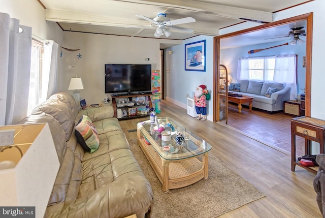 living room featuring wood-type flooring, ceiling fan, and beamed ceiling