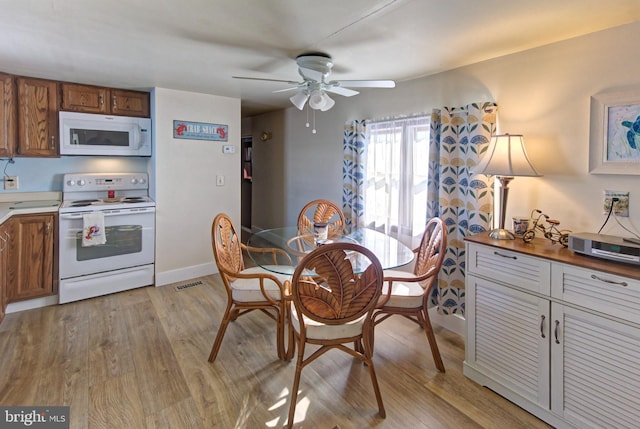 dining area with ceiling fan and light hardwood / wood-style flooring