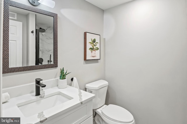 bathroom with walk in shower, vanity, and toilet