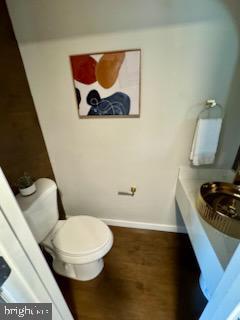 bathroom featuring wood-type flooring and toilet