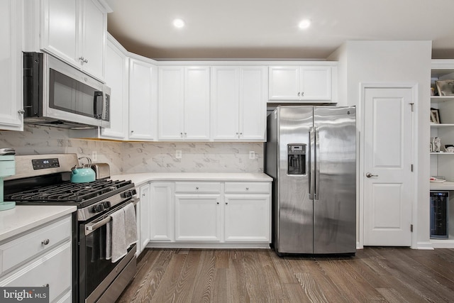 kitchen featuring white cabinets, dark hardwood / wood-style floors, stainless steel appliances, and tasteful backsplash