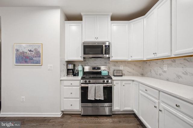 kitchen featuring decorative backsplash, white cabinetry, appliances with stainless steel finishes, and dark hardwood / wood-style flooring