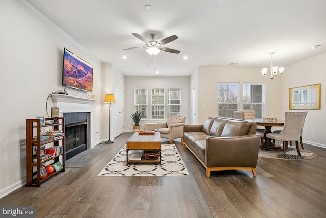 living room featuring ceiling fan with notable chandelier and hardwood / wood-style floors