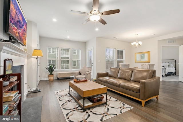 living room featuring dark hardwood / wood-style floors and ceiling fan with notable chandelier