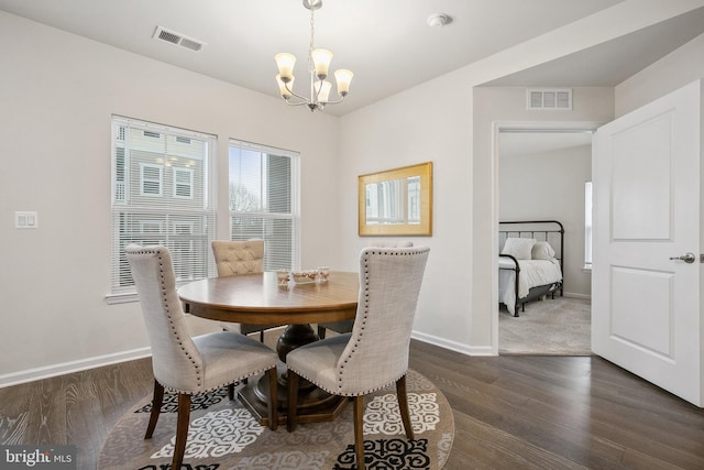 dining area featuring dark hardwood / wood-style floors and a notable chandelier