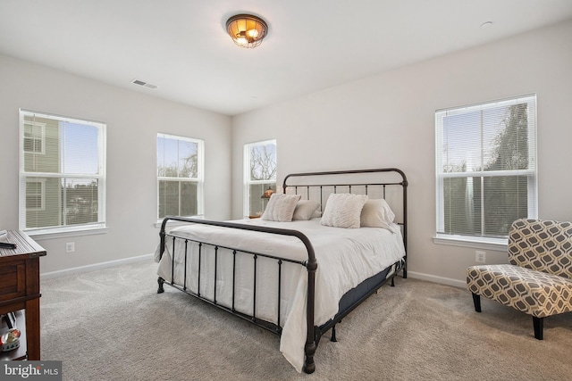 carpeted bedroom featuring multiple windows