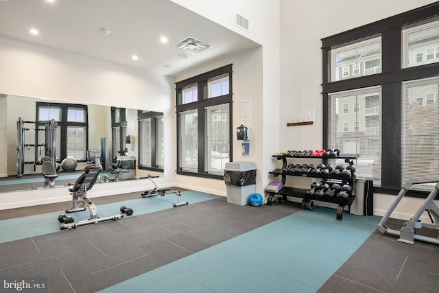 workout area with a high ceiling and a healthy amount of sunlight