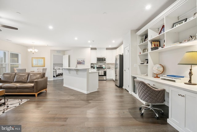 office area with dark wood-type flooring, a notable chandelier, and built in desk