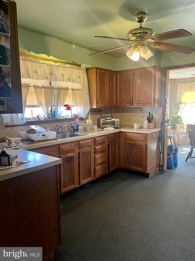 kitchen featuring ceiling fan and dark carpet