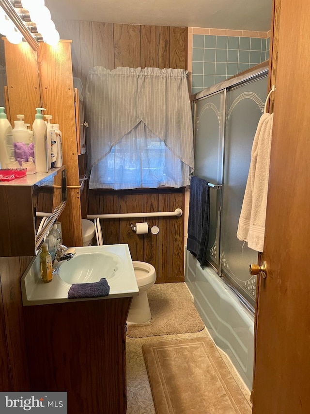 full bathroom featuring toilet, combined bath / shower with glass door, and vanity