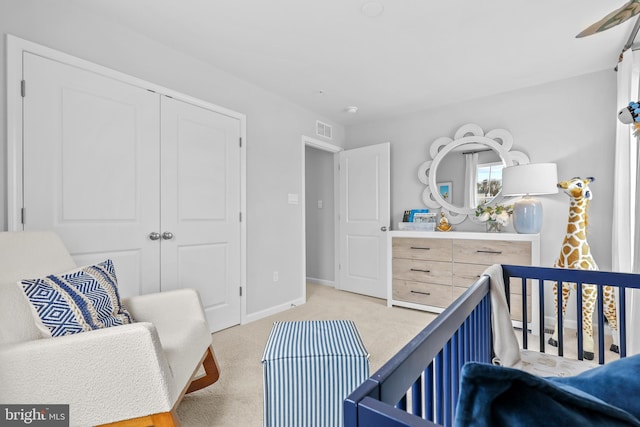 carpeted bedroom featuring a nursery area