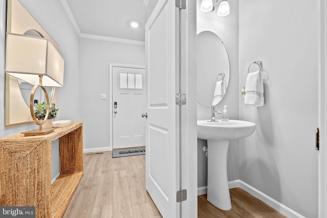 bathroom with hardwood / wood-style floors and crown molding