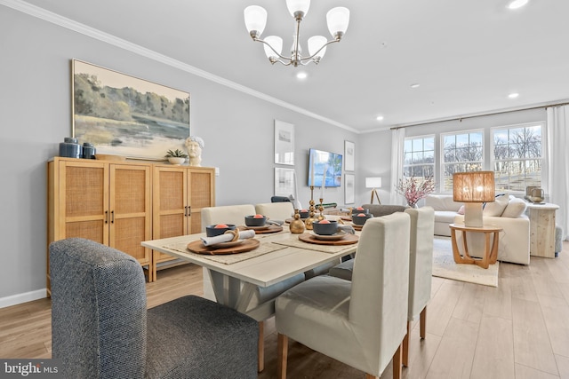 dining area featuring light hardwood / wood-style floors, an inviting chandelier, and crown molding