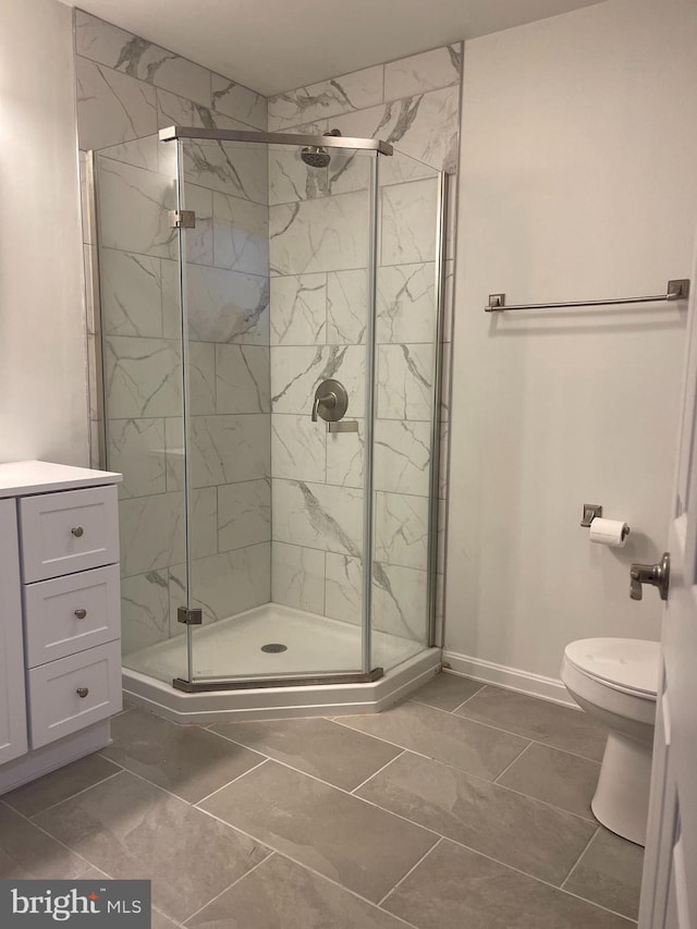 bathroom featuring vanity, toilet, and an enclosed shower