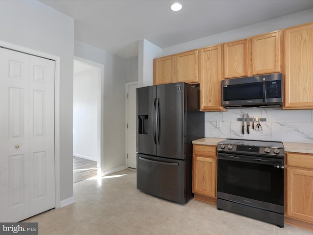 kitchen featuring light brown cabinetry, backsplash, range with electric stovetop, and black refrigerator with ice dispenser