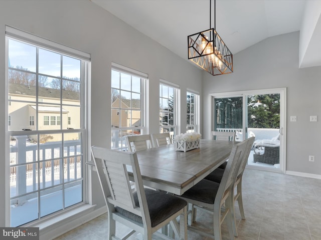 tiled dining room featuring vaulted ceiling and a chandelier